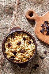 Wall Mural - Sweet millet porridge with dark raisins in ceramic rustic bowl