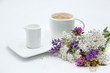 A cup of coffee with milk and a bouquet of lavander