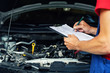 © ronstik - car maintenance and repair - mechanic writing checklist paper on clipboard