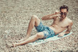 © Teodor Lazarev - Sexy young guy lying on the beach