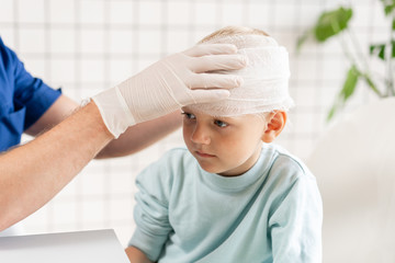 Wall Mural - Doctor bandaged a boy head with trauma in his head and elastic bandaged around his head