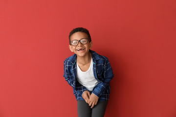 Wall Mural - Laughing African-American boy on color background