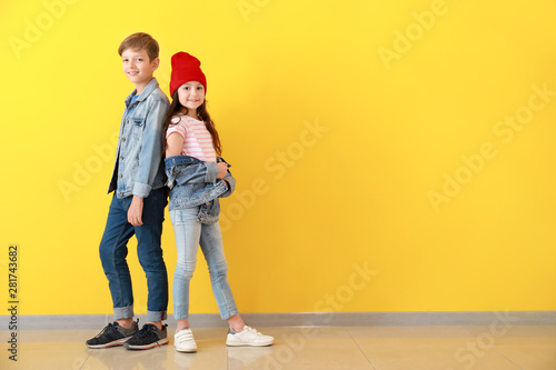 Cuadros en Lienzo Stylish children in jeans clothes near color wall