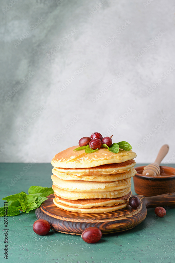 Tasty pancakes with gooseberry on table