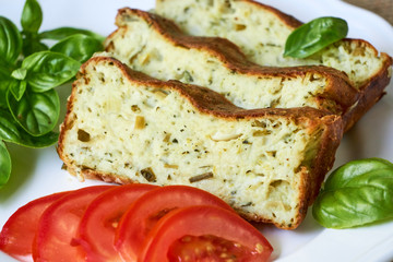 Wall Mural - Casserole with zucchini, cheese and fresh herbs on a white plate