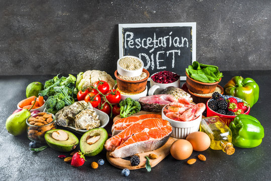 Pescetarian diet plan ingredients, healthy balanced grocery food, fresh fruit, berries, fish and shellfish clams,  black background copy space 