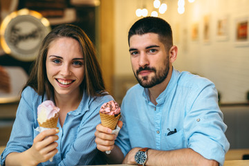 couple having fun eating ice cream in cafe