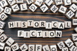 historical fiction - word from wooden blocks with letters, Literary Genres concept, random letters around, top view on wooden background