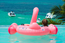 Caucasian Teenager Girl With Inflatable Flamingo Relaxing In Infinity Swimming Pool In Luxury Hotel Looking At The View, Punta Cana, Dominican Republic. Summer Vacation Concept