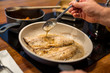 Fischfilets in Pfanne, heiße braune Butter schaumig, Löffel in der Hand, übergießen, Nahaufnahme