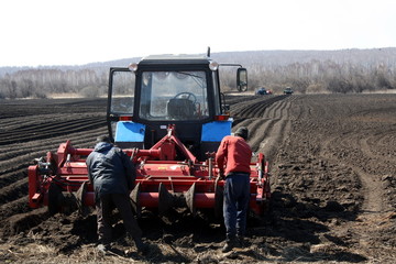 MOSCOW - MAY 2, 2019 field work on the preparation of land in the spring for sowing. The black earth moves away into perspective