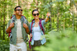 © Syda Productions - travel, tourism, hike and people concept - mixed race couple with backpacks in forest