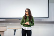 © Danon - Portrait of a young, beautiful, attractive and intelligent-looking Indian Asian woman wearing spectacles in a sweater giving a business presentation to an audience.