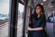 © Danon - Portrait of a tall, slim, elegant and beautiful Indian Asian woman taking the train alone. She is leaning near the window and watching the scenery go by. The train is modern and clean.