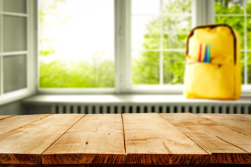 Wall Mural - Wooden table desk with a window and yellow schoolbag. Empty space for you decoration and products.