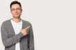 Sceptic guy pose on grey background pointing finger aside copyspace