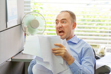 Stressed Businessman Throwing Charts Or Paperwork At Office, Businessman Throws Paper Document Pages In Office. Overworked Angry Businessman Throwing Paper All Over The Office.