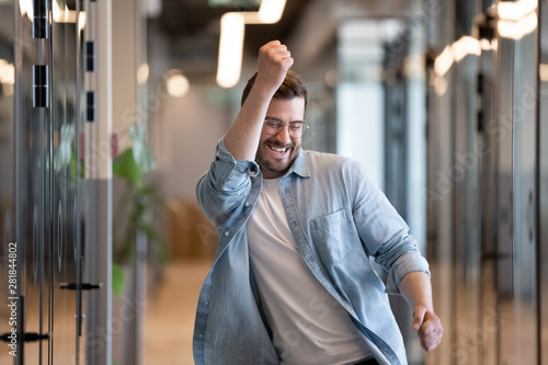 Cuadros en Lienzo Ecstatic male winner dancing in office hallway laughing celebrating success