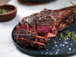 © The Picture Pantry - Sliced medium rare grilled angus beef tomahawk steak on a dark plate