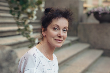 A beautiful tourist of Mature age sits on the steps in the city of St. Petersburg