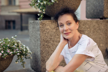 A beautiful tourist of Mature age sits on the steps in the city of St. Petersburg