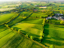 Aerial View Of Endless Lush Pastures And Farmlands Of Ireland. Beautiful Irish Countryside With Green Fields And Meadows. Rural Landscape On Sunset.