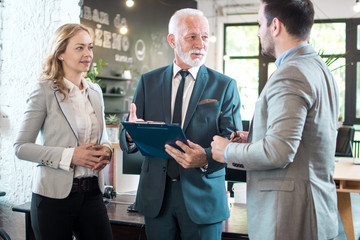 business people discussing document during informal meeting in office