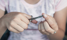 Young Girl Cuts Her Nails With Scissors.