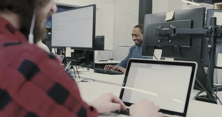 Young multiethnic business team of software developers working together using