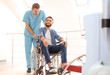 © Africa Studio - Male doctor taking care of man in wheelchair indoors