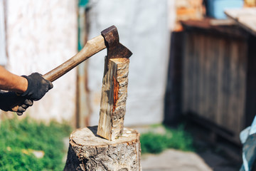 Ready for cutting timber. Close-up of axe cutting log while other logs laying in the background