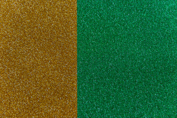 Wall Mural - Golden and green sparkling background from small sequins, closeup. Brilliant shiny backdrop from textile. Shimmer paper