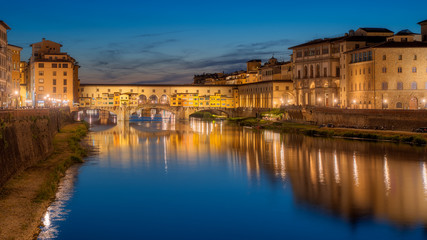 Wall Mural - Ponte Vecchio bridge over Arno river in Florence city, Italy in the sunset