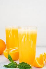 Two glasses of freshly squeezed orange juice on white background