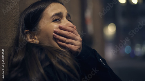 Cuadros en Lienzo Shocked robber victim crying at night street, panic attack, psychological trauma