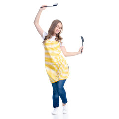 Woman in yellow apron with kitchen utensils tools in hand happiness dancing on white background isolation