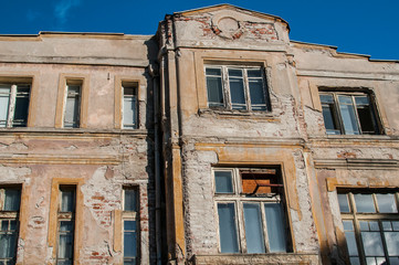 Wall Mural - Old retro building weathered neglected facade closeup in sunny day