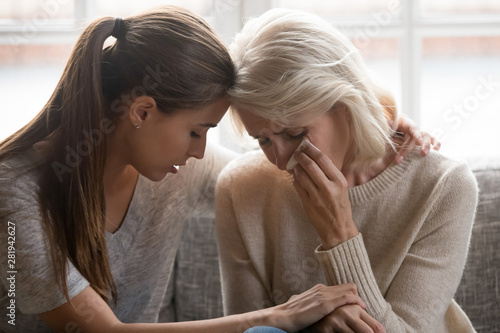 Cuadros en Lienzo Grownup daughter soothe aged mother holds her hand feeling empathy