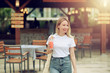 © Artem - Portrait of smiling young woman with glass of fresh fruit smoothie in street bar.