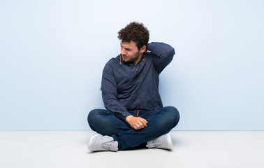 Young man sitting on the floor with neckache