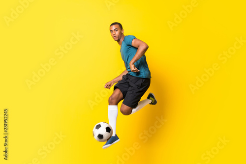 Fotografía Afro American football player man over isolated yellow background