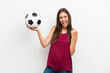 © luismolinero - Young woman over isolated white background holding a soccer ball