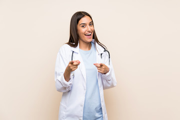 Young doctor woman over isolated background points finger at you