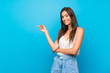 © luismolinero - Young woman over isolated blue background pointing finger to the side