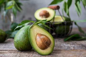 Fresh green avocado on wooden background. Selective focus. Horizontal orientation.