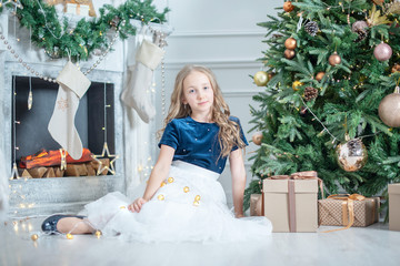 Wall Mural - portrait of a girl in Christmas decorations. child enjoy the holiday near Christmas tree. 