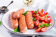 Grilled sausage with tomatoes, basil salad and red onions. BBQ menu.