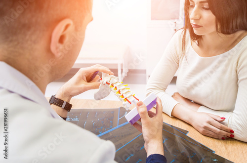 Fotomural Orthopedist showing spine model to patient in hospital