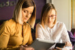 © Miljan Živković - Two business woman checking data on the digital tablet computer and mobile smart phone during the consultation on the coffee brake meeting making plans for future project