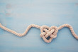 © vetre - Heart shaped knot on blue wooden background